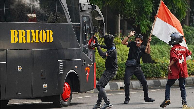 Ein Student wirft einen Stein auf ein Polizeifahrzeug bei gewalttätigen Protesten gegen üppigen Zulagen für Parlamentsmitglieder in Indonesien.