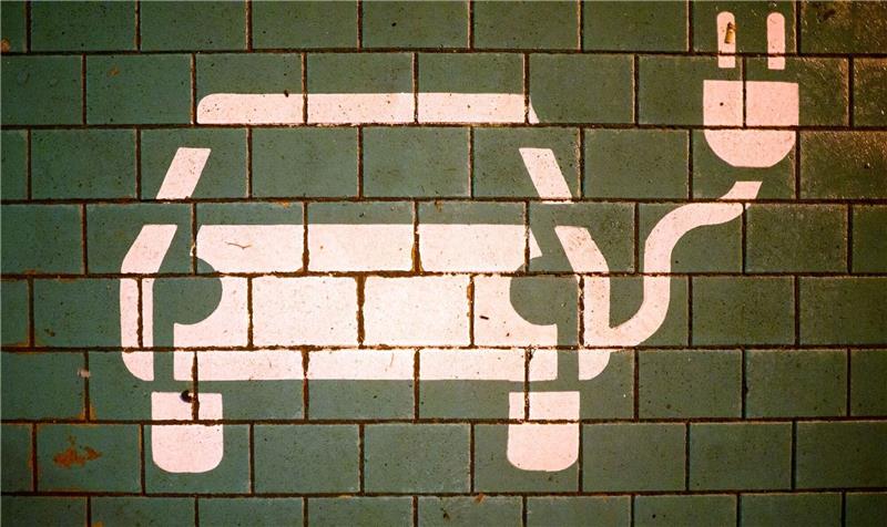Nachfrage nach Elektroautos steigt weiter Ein Symbol markiert einen Parkplatz mit einer öffentlichen Ladesäule für Elektroautos.