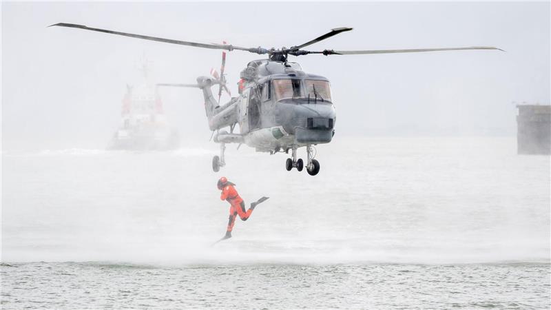 Ein Taucher springt im Rahmen einer Vorführung auf dem Marinestützpunkt Wilhelmshaven aus einem Hubschrauber.