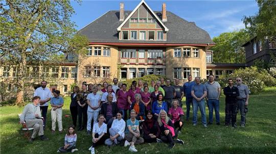 Ein Teil der insgesamt 130 Mitarbeiter des Sanatoriums Dr. Barner stellt sich vor dem historischen Jugendstil-Ensemble zu einem Gruppenfoto zusammen.
