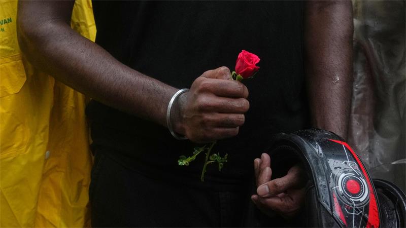 Ein Teilnehmer einer Demonstration hält während einer Kundgebung für Bildungsreformen im Rahmen der anhaltenden Protestbewegung der „Cockroach Janta Party“ eine Blume in der Hand.