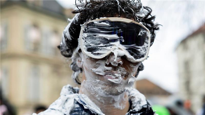 Ein Teilnehmer ist beim „Picoulet“ in Genf verkleidet und voller Rasierschaum. Bei dem traditionellen bunten Umzug mit Musik kommt es oft zu wahren Schaumschlachten.
