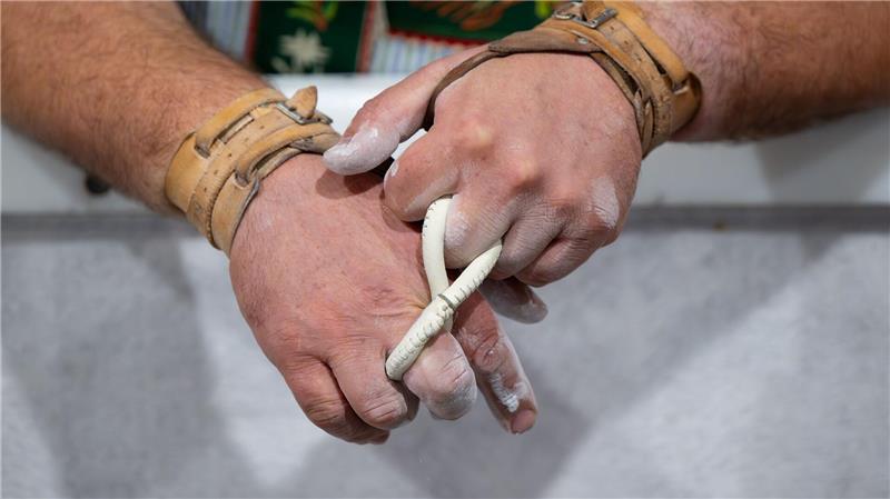 Ein Teilnehmer wärmt sich vor einem Wettkapf um die Bayerische Meisterschaft im Fingerhakeln in Mittenwald auf.