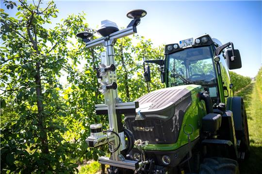 Ein Traktor, ausgestattet mit Technik aus dem Projekt «SAMSON» fährt durch die Baumreihen.