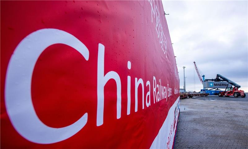 Scholz in Peking: Wie abhängig ist die deutsche Wirtschaft? Ein Transparent mit der Aufschrift „China Railway Express“ hängt an einer Lokomotive, die Waggons mit den ersten Containern einer neuen „Seidenstraßen“-Verbindung zwischen China und Deutschland durch den Seehafen von Mukran zieht.