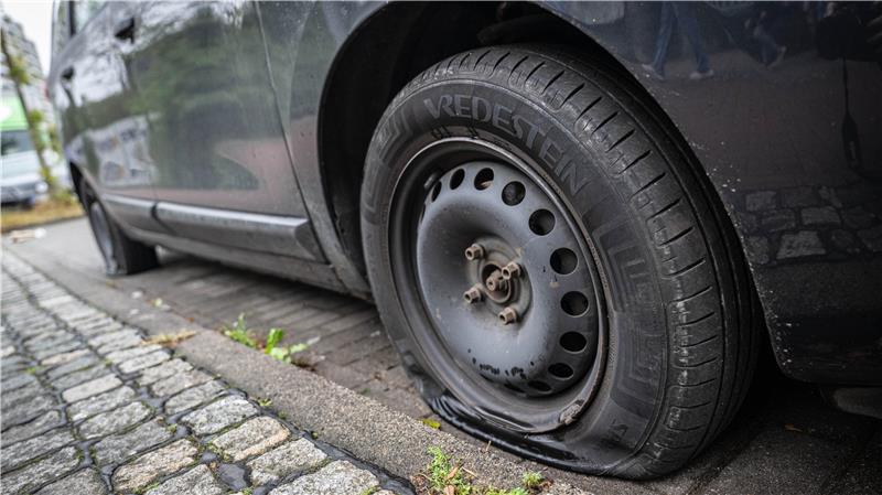 Ein Auto mit plattem Reifen steht im Bremer Ortsteil Tenever. 