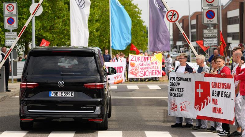 VW-Chef: Kosten zu hoch - Einschnitte im Management Ein VW-Bus mit VW-Vorstandschef Oliver Blume passiert die Demonstration von Beschäftigten am Werkstor des Standortes Zwickau.