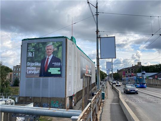 Ein Wahlplakat der liberalkonservativen Regierungspartei mit einem Porträt von Ministerpräsident Krisjanis Karins hängt an einer Hauswand in der Hauptstadt Riga.