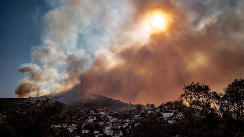 Ein Waldbrand im Collserola-Gebirge lässt Rauch über den Stadtteil Nou Barris in Barcelona ziehen.