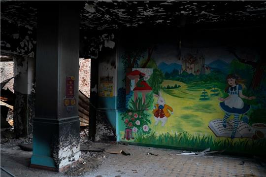 Ein Wandgemälde ziert eine Wand in einer stark beschädigten Schule in der durch ukrainische Streitkräfte zurückeroberten Stadt Lyman.