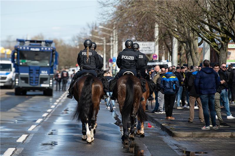 Ein Wasserwerfer der Polizei steht vor dem Spiel nahe dem Eintracht-Stadion hinter der Reiterstaffel. Foto: Swen Pförtner/DPA