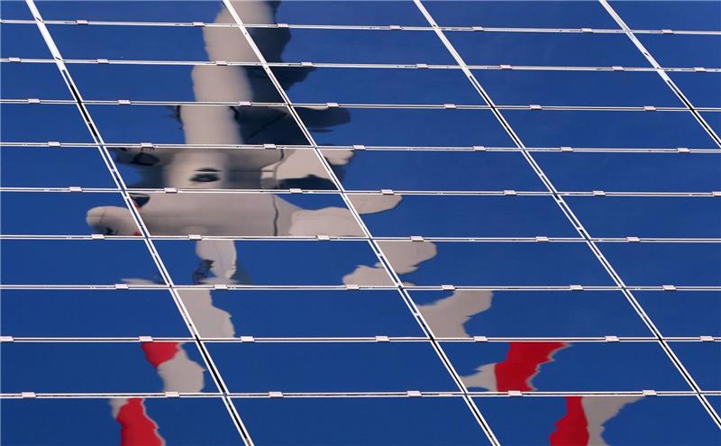 Bayern mit Abstand vorn beim Ausbau erneuerbarer Energie Ein Windrad spiegelt sich in eine Solar-Anlage eines Solarparks in Bayern: Vor allem Solaranlagen spielen in Bayern eine große Rolle.