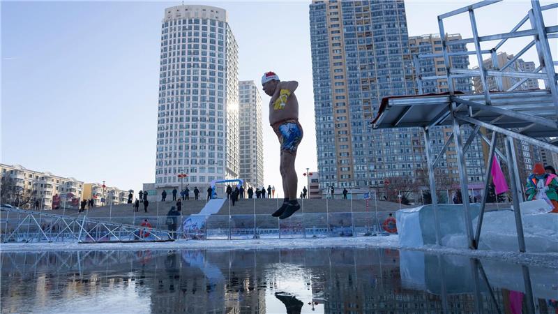 Ein Winterschwimmer springt in Harbin in der chinesischen Provinz Heilongjiang ins eiskalte Wasser.