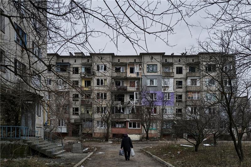 UN-Bericht: Zivilisten in russischem Gewahrsam gefoltert Ein Zivilist geht an schwer beschädigten Wohngebäuden in Soledar vorbei.