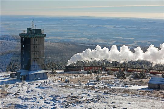 Ein Zug der Harzer Schmalspurbahnen fährt mit langer Rauchfahne zum Brocken. Foto: Matthias Bein/dpa