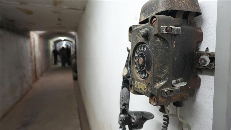 Ein altes Telefon hängt an der Wand.