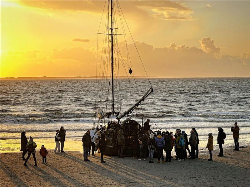 Ein am Weststrand der Insel Norderney gestrandetes Segelschiff mit Schaulustigen.