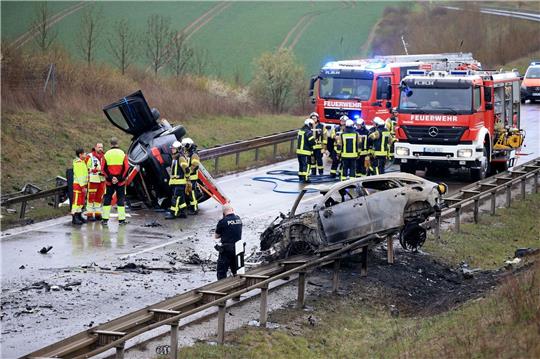 Ein ausgebrannter PKW und ein weiteres verunfalltes Fahrzeug stehen an der Unfallstelle auf der B247 bei Bad Langensalza in Thüringen.