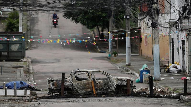 Ein ausgebranntes Auto versperrt eine Straße in der Favela „Complexo de Israel“, nahe weiterer Favelas, in denen die Polizei derzeit Razzien gegen Drogenbanden durchführt.