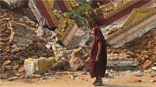 Ein buddhistischer Mönch geht in der Nähe einer eingestürzten Pagode nach einem Erdbeben in Mandalay. 