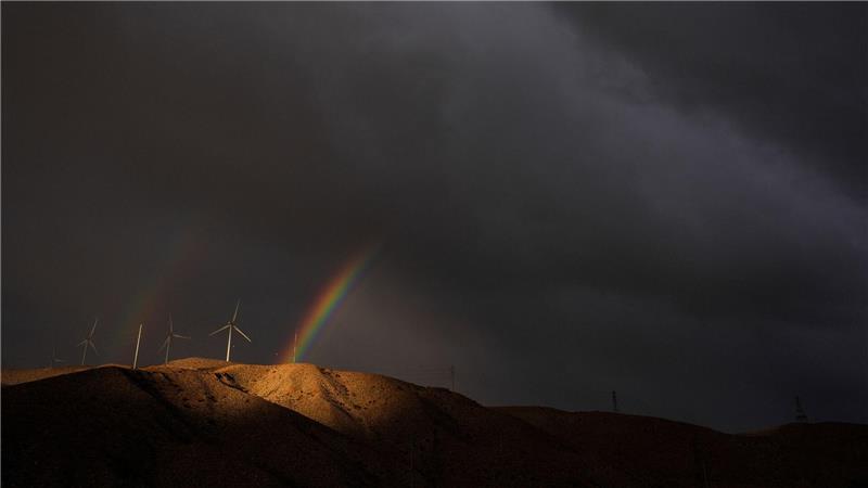 Ein doppelter Regenbogen erscheint hinter Windturbinen unter Gewitterwolken in der Nähe von Cathedral City in Kalifornien.