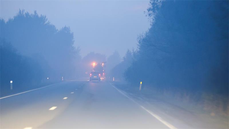 Brand im Hohen Venn: Evakuierung bei Monschau angeordnet Ein durch den Qualm des Feuers verrauchte Straße bei der Stadt Sourbrodt.
