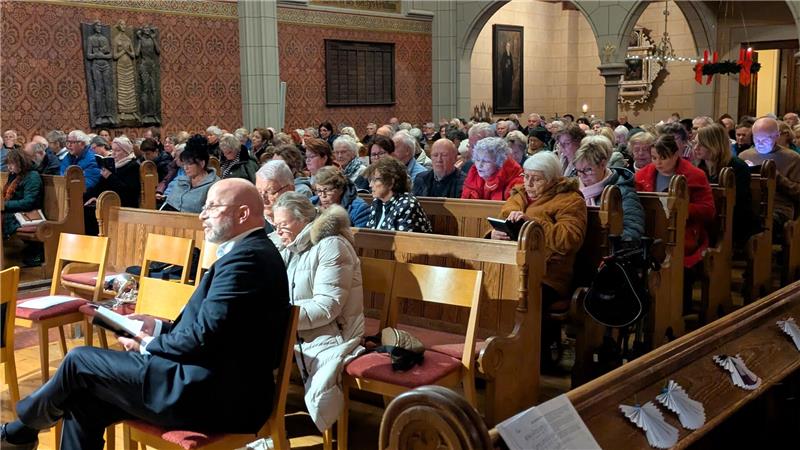 Ein eher untypischer Anblick: Während des Adventsliedersingens schauen viele Gemeindemitglieder lieber auf ihr Smartphone statt ins gedruckte Gesangbuch.