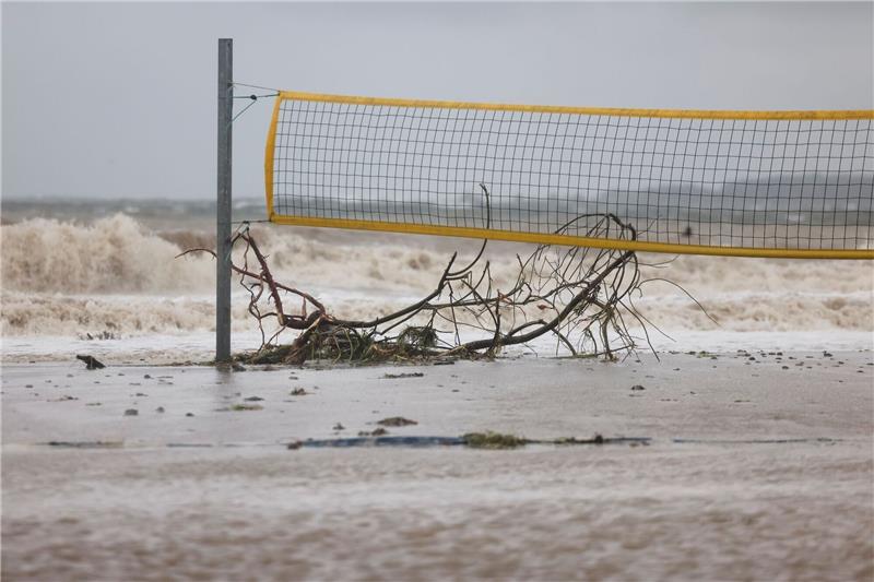 Schwere Sturmflut setzt der Ostsee-Küste zu - Eine Tote Ein entwurzelter Baum liegt unter einem Volleyballnetz am Ostseestrand von Eckernförde.
