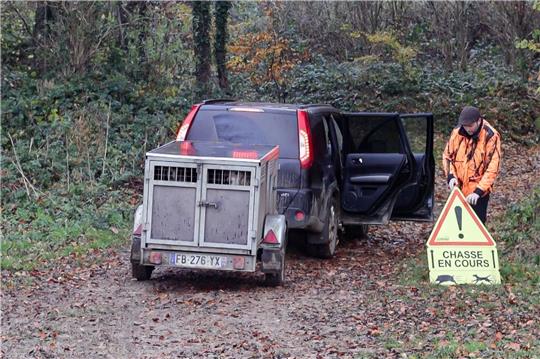 Ein französischer Jäger stellt ein Schild auf, das Spaziergänger vor einer Drückjagd warnt.