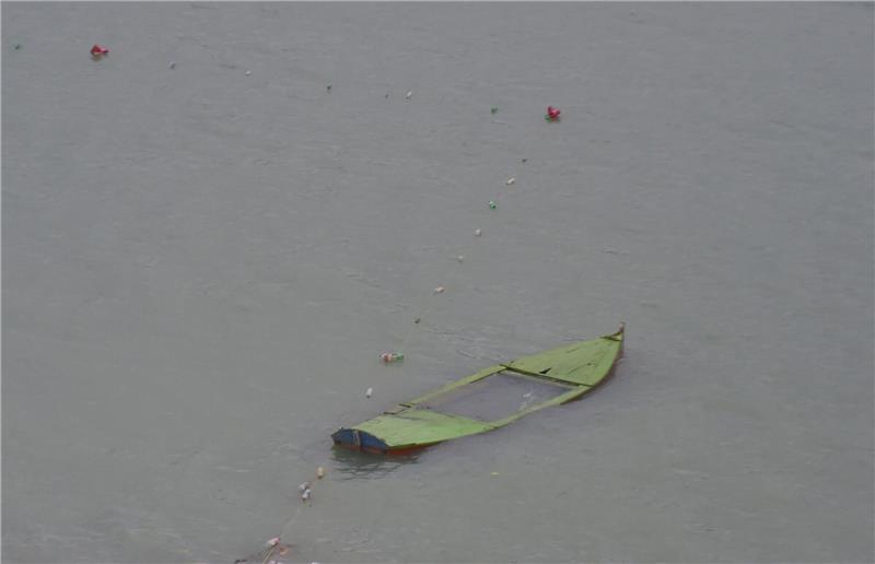 Ein gekentertes Boot treibt auf dem Tanda-See in der pakistanischen Provinz Khyber Pakhtunkhwa.