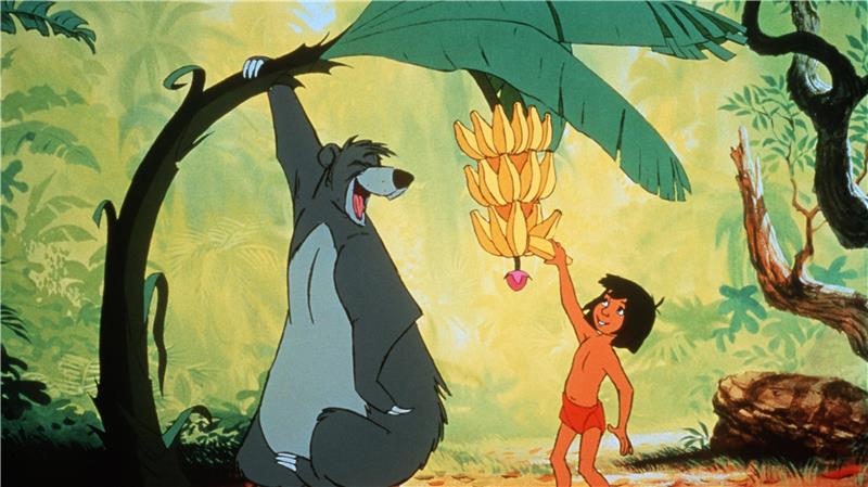 Ein sitzender Bär biegt einen Baumstamm nach unten, damit ein Junge sich aus der Krone eine Banane pflücken kann. Beide sind umgeben von Dschungelpflanzen.