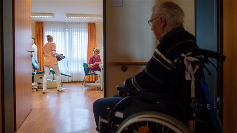 Ein im Rollstuhl sitzender Heimbewohner wartet vor dem Behandlungszimmer der Zahnärztin auf seine Zahnuntersuchung: Im Landkreis Goslar sind die Sozialkosten deutlich gestiegen, dadurch fällt das Minus im Haushalt deutlich größer aus.