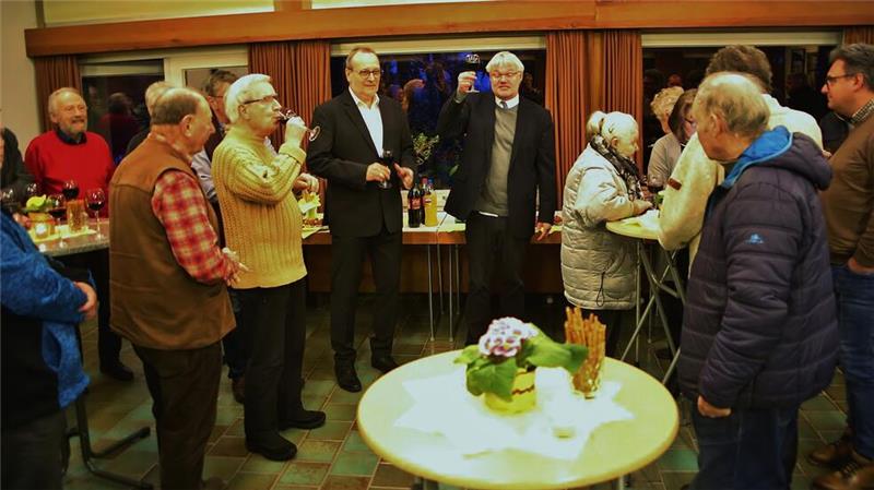 Neujahrsempfang sorgt für voll besetzte Kirche Ein kleiner Empfang rundet den Neujahrsempfang ab. Pfarrer Andreas Widlowski (Mitte rechts) prostet den Besucherinnen und Besuchern zu.