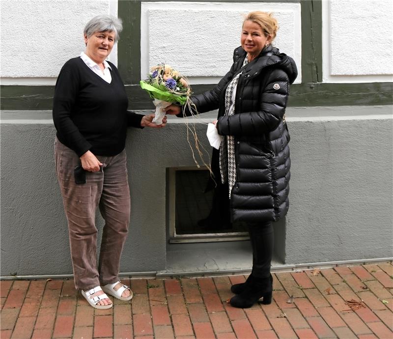 Ein kleiner Strauß und ein großes „Sorry“: Oberbürgermeisterin Urte Schwerdtner (rechts) teilt Marianne Gottschling mit, dass sie ihre hellen Fensterrahmen in der Altstadt behalten darf.  Foto: Hartmann