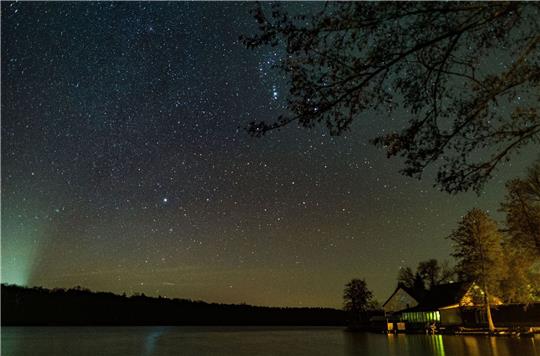 Ein kleiner Teil der Milchstraße ist am nächtlichen Sternenhimmel über dem Schwarzen See im Landkreis Märkisch-Oderland zu sehen.