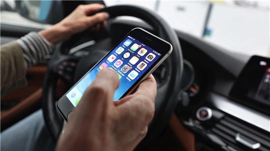 Ein „kurzer“ Blick auf das Handy ist bisher erlaubt - wenn man es nicht in die Hand nimmt. (Symbolbild)