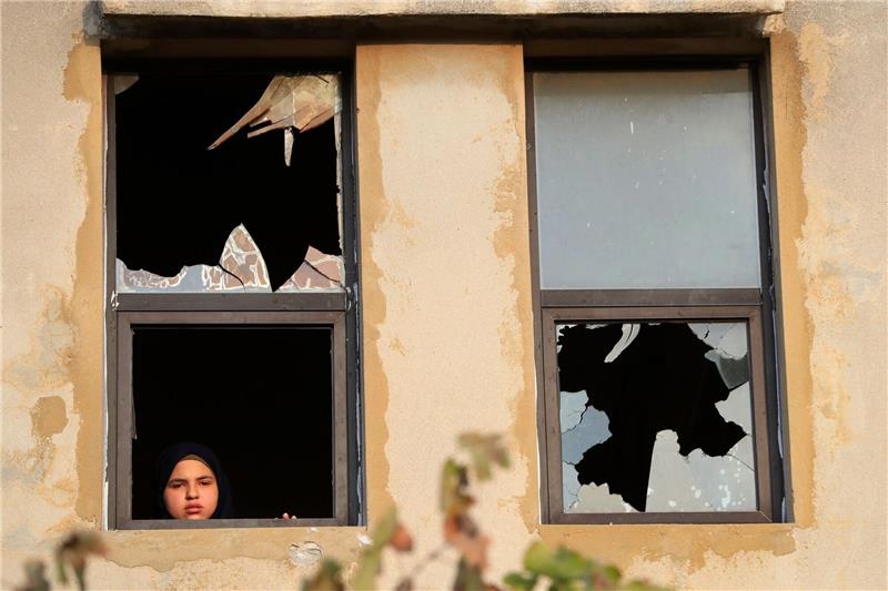 Ein libanesisches Mädchen blickt nach israelischem Beschuss auf ein Dorf im Südlibanon durch ein zerbrochenes Fenster.