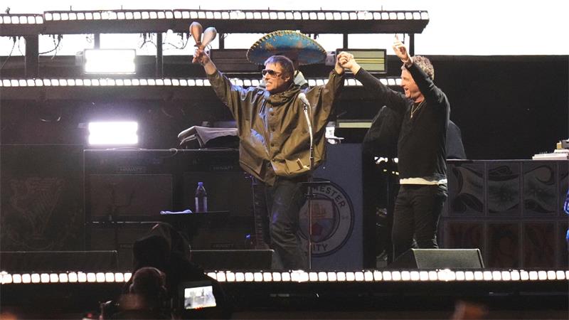 Britpopband Oasis kündigt Konzerte in Deutschland an Ein nach wie vor ungewohntes Bild: Liam und Noel Gallagher Hand in Hand auf der Bühne. (Archivbild)