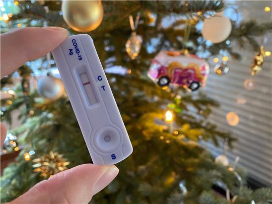 Ein negativer Schnelltest für das Coronavirus, fotografiert vor einem Weihnachtsbaum. Befürchtungen vor einer Infektionen spielen laut einer Umfrage keine größere Rolle mehr.