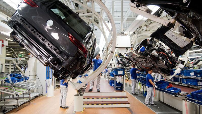 VW will Bachelor-Absolventen in Produktion einsetzen Ein neuer Volkswagen Golf 8 (l) schwebt an einer Produktionslinie im VW Werk.