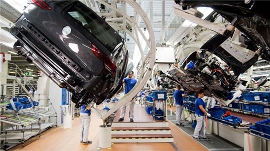Ein neuer Volkswagen Golf 8 (l) schwebt an einer Produktionslinie im VW Werk.