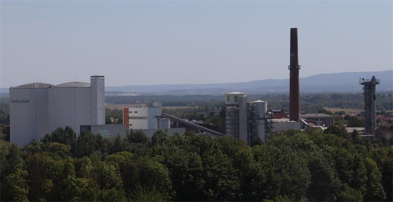 Eine Zuckerfabrik mit Silos und einem Schornstein.