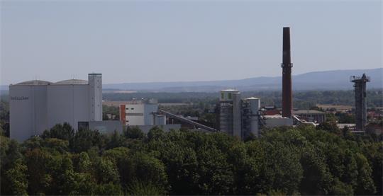 Eine Zuckerfabrik mit Silos und einem Schornstein.