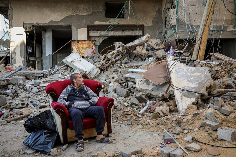 Wie geht es weiter mit der Feuerpause - und danach? Ein palästinensischer Mann sitzt in einem Sessel vor einem zerstörten Gebäude in Gaza-Stadt.