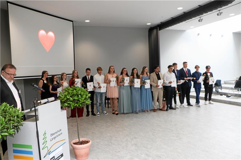 Ein rotes Herz prangt auf der Leinwand, als Schulleiter Klaus Scheller (li.) der Klasse 10 c die Zeugnisse überreicht.  Fotos: Böhl