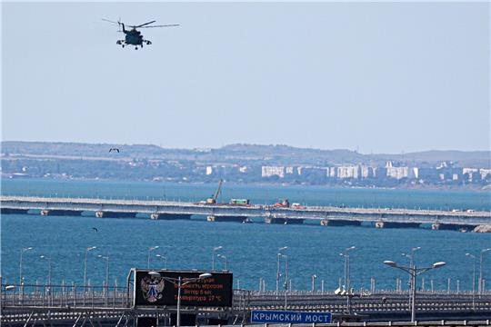 Ein russischer Militärhubschrauber überfliegt die beschädigten Teile einer Automobilverbindung der Krim-Brücke.