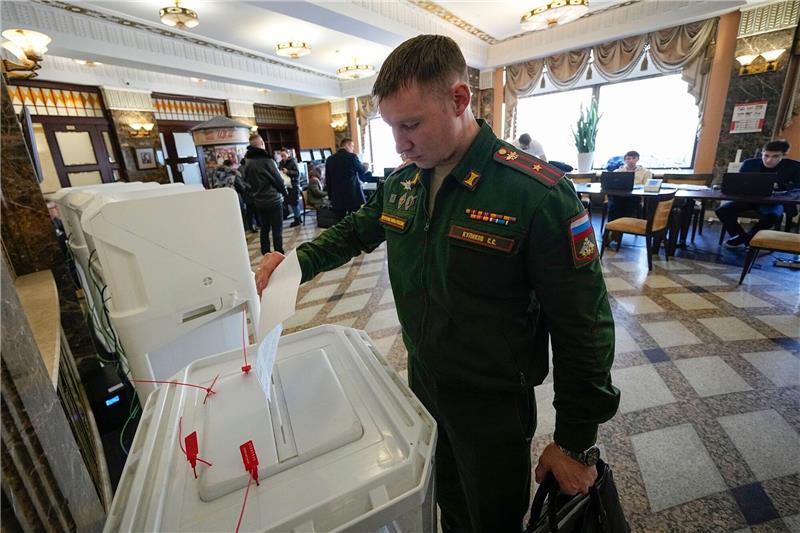 Präsident „gesucht”: Putin lässt wählen Ein russischer Soldat gibt während der Präsidentschaftswahl in einem Wahllokal Moskau seine Stimme ab.