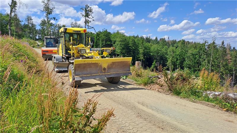 Bad Harzburg: Forst befreit den Wald von Asphalt Ein sogenannter Grader (rechts) verteilt den neuen Schotter auf der Käste- und der Goldbergstraße. Anschließend wird er durch eine Walze verdichtet. Foto: Landesforsten