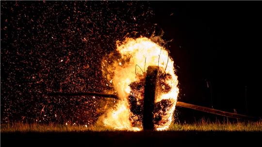 Ein sogenanntes Osterrad läuft, hier im vergangenen Jahr, brennend einen Hügel herunter und zieht eine Feuerspur hinter sich her. (Archivbild)