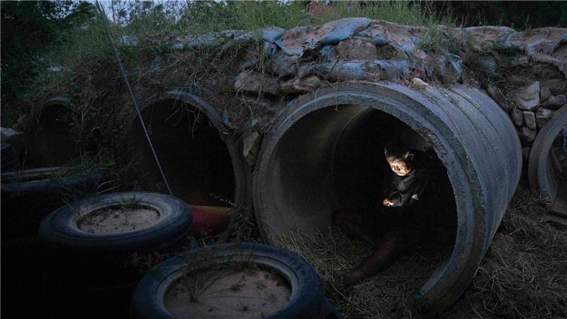 Ein thailändischer Einwohner, der vor Zusammenstößen zwischen thailändischen und kambodschanischen Soldaten geflohen ist, benutzt sein Mobiltelefon, während er in der thailändischen Provinz Buriram Schutz sucht.